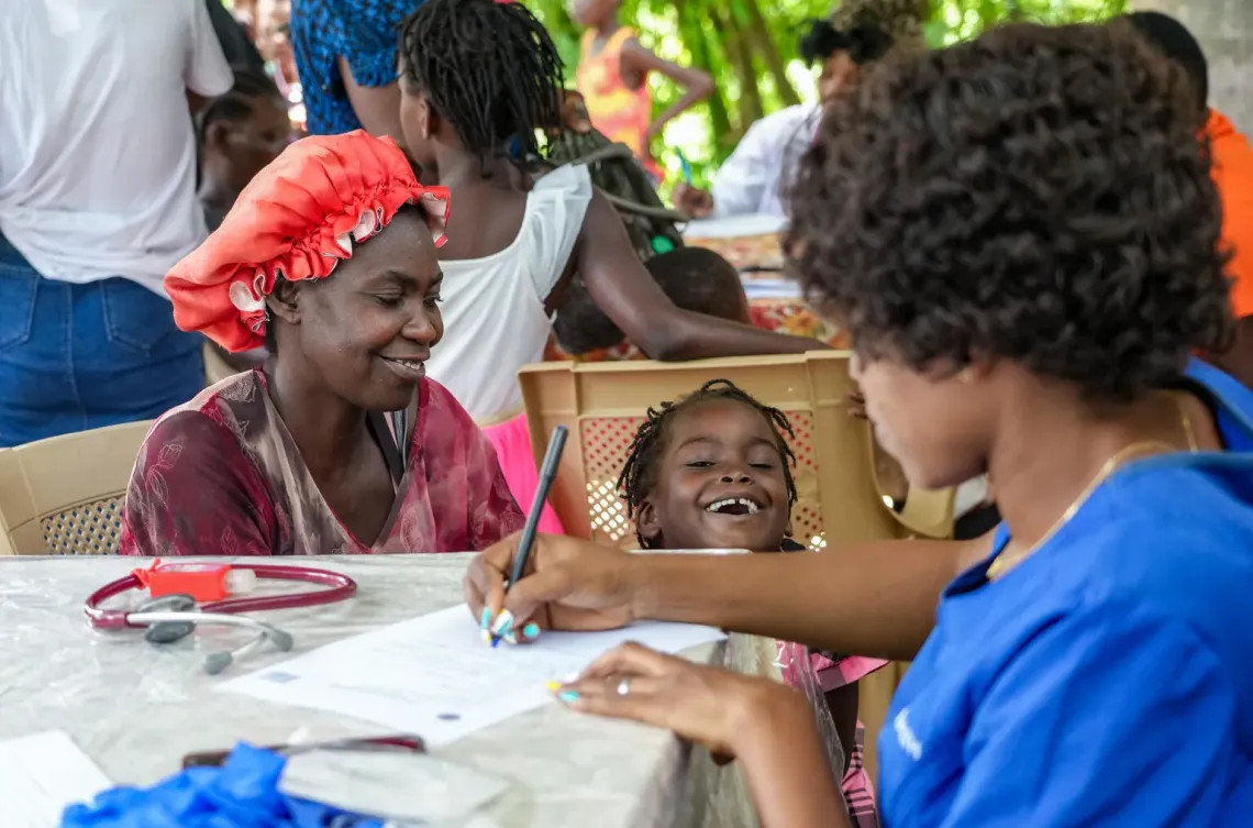 UNICEF/UNI792740/Joseph Una madre que huyo de la violencia armada de Morne Blanc, Haití, está sentada con su hija en una clínica móvil apoyada por UNICEF en Boucan Carré, Haití.