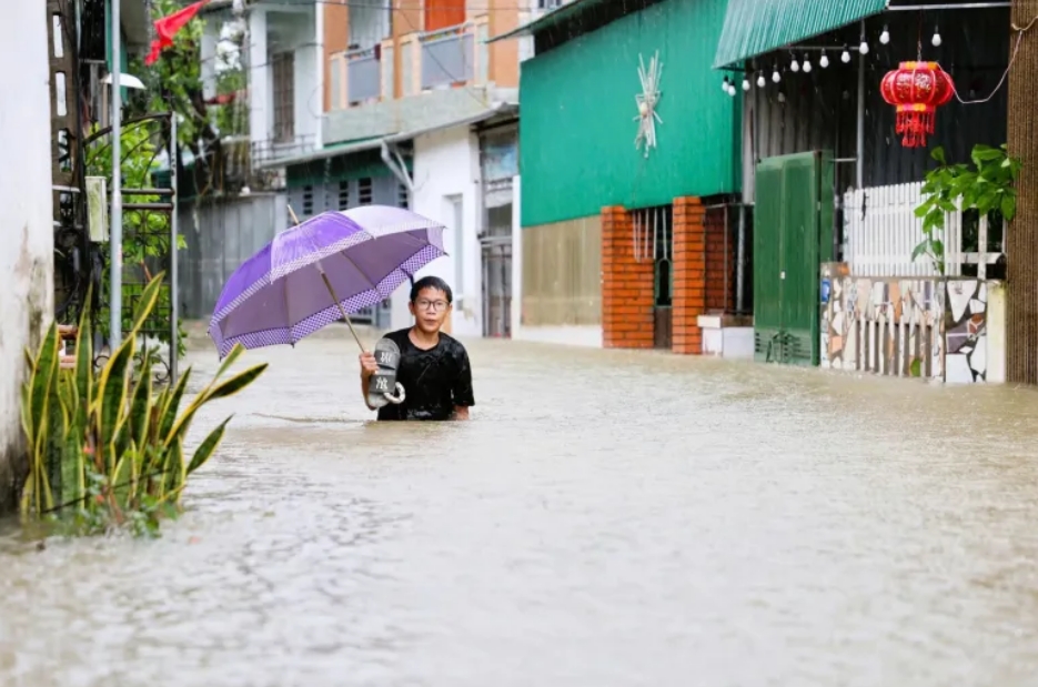 UNICEF/UNI870430/Do Khuong Duy Hoang Trung Thanh, de 15 años, se encuentra en una zona inundada de Truong Vinh, en la ciudad de Vinh, en el centro de Vietnam, tras el paso de la tormenta tropical Bualoi en septiembre de 2025.